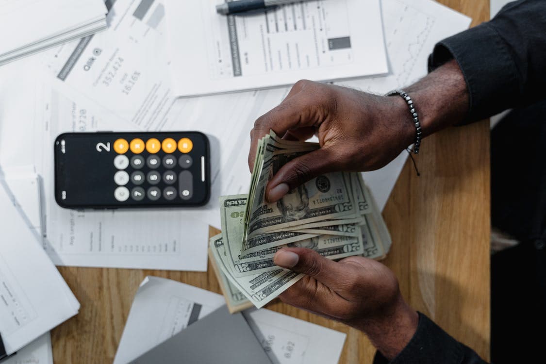Person managing finances with calculator and documents