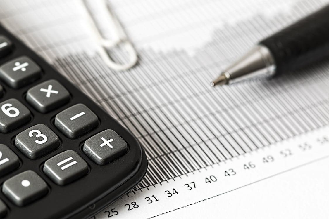 Calculator and pen on financial charts